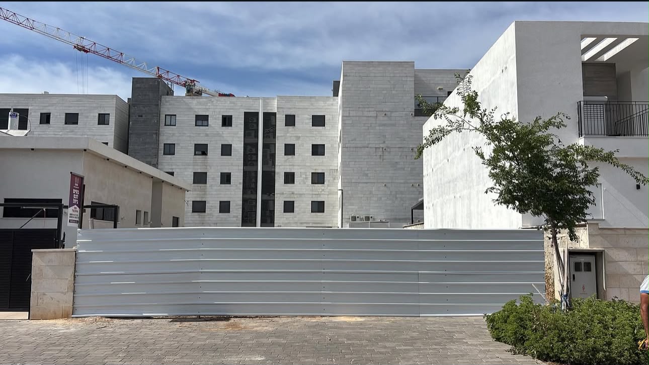 Long grey panel fence securing a construction site in a residential area