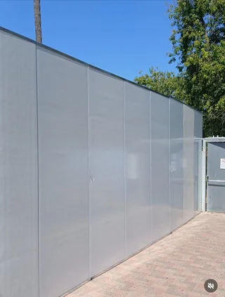 גדר פאנל אפורה גבוהה עם שער כניסה תואם